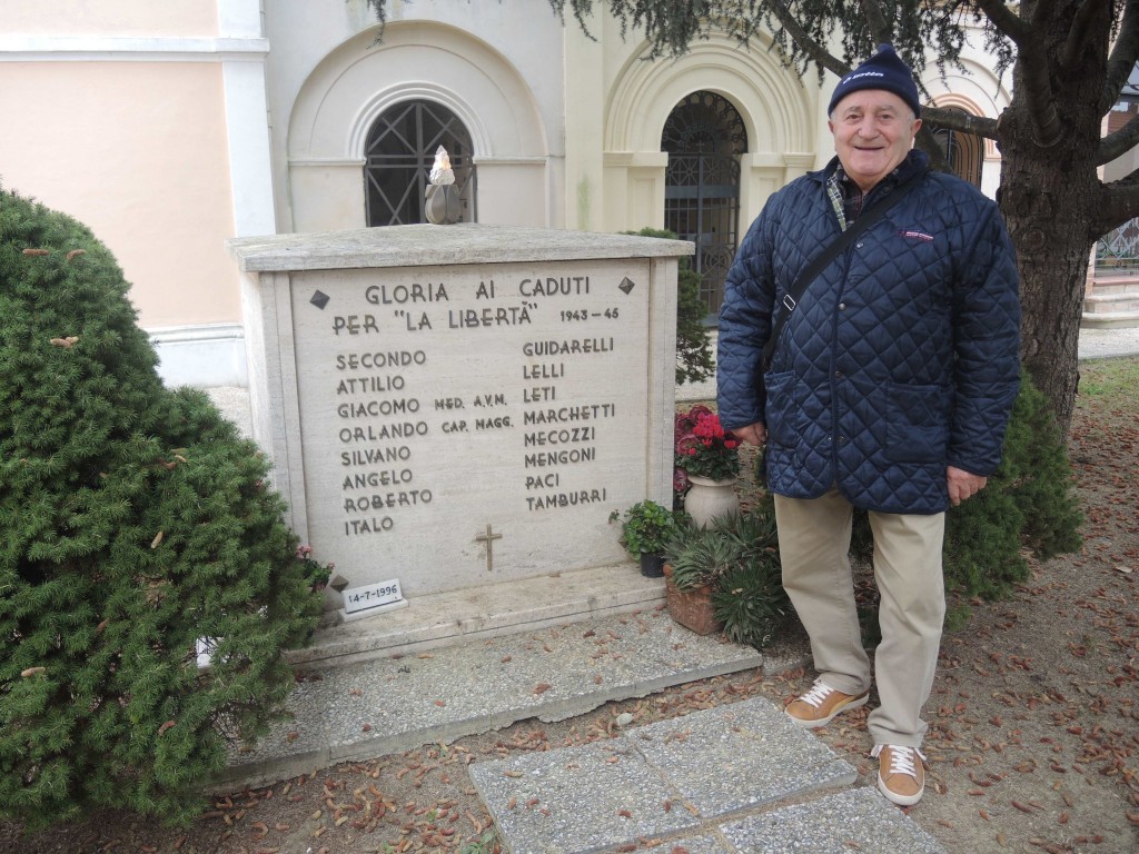 Alberto Mogianesi accanto al sarcofago con i resti mortali degli otto partigiani del luogo