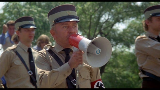 Un fotogramma che rappresenta i nazisti dell’Illinois (diventato poi un mantra) dal film The Blues Brothers. Ma i nazisti dell’Illinois non sono un’invenzione cinematografica